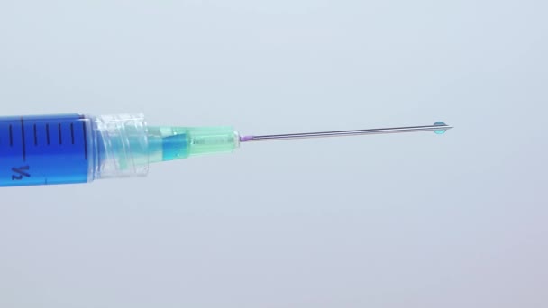 Blízká vodorovná injekční stříkačka kapající modrá kapalina pomalu — Stock video