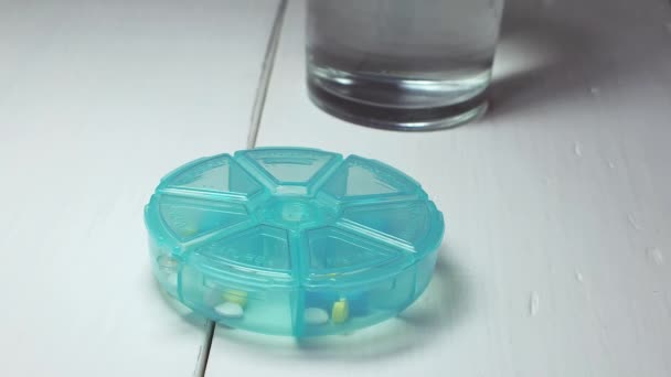 从蓝色塑料盒中取出蓝色药丸的人 — 图库视频影像