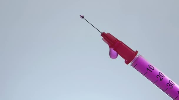 Schuine insuline spuit met roze vloeistof druppelen — Stockvideo