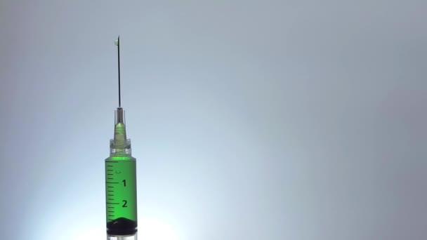 Вертикальный шприц капающий зеленой жидкостью — стоковое видео