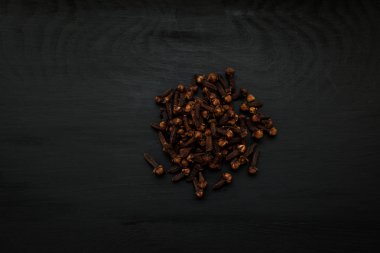 Yakın çekim görüntü üzerinde siyah ahşap arka plan, Kuru karanfil görünümü yukarıdaki