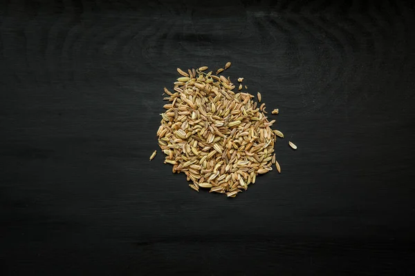 Yakın çekim görüntü üzerinde siyah ahşap arka plan, rezene tohumu görünümü yukarıdaki