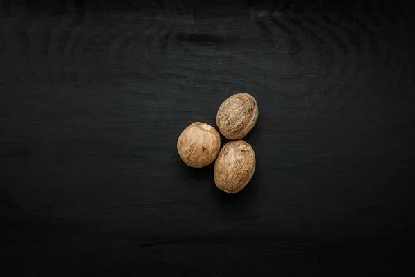 Yakın çekim görüntü siyah ahşap zemin üzerine Hindistan cevizi görünümü yukarıdaki