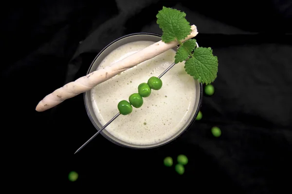 Rustik koyu arka plan üzerinde grisini ile yeşil bezelye çorbası
