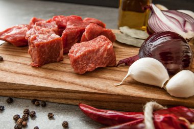 Otlar ve petrol taş arka plan üzerinde eski rustik Ahşap mutfak panosunda pişmemiş taze doğranmış Dana etli.