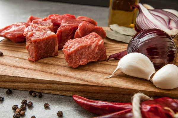 Otlar ve petrol taş arka plan üzerinde eski rustik Ahşap mutfak panosunda pişmemiş taze doğranmış Dana etli.