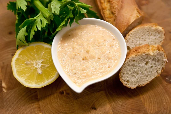 Limon ve maydanoz ile süslenmiş beyaz tabak içinde geleneksel taramosalata.