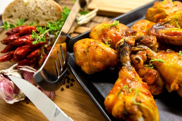 Bir ahşap tahta üzerine kızarmış tavuk uyluk zencefil, biber ve soğan ile servis