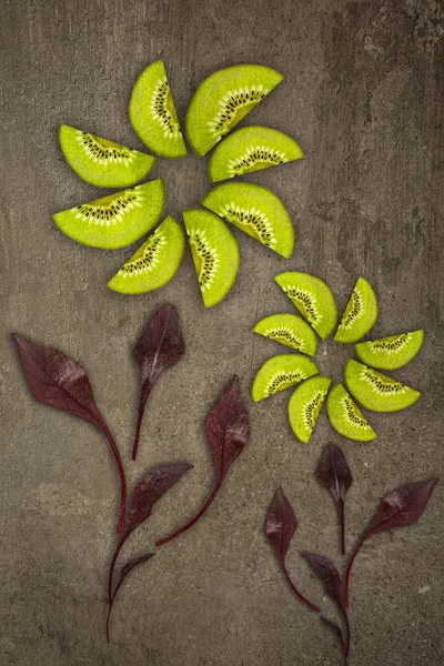 Yaratıcı çiçek kivi aşağıdan kesmek pancar yaprakları ile yapılan bir taş arka plan gıda kavramı üzerinde yaktı