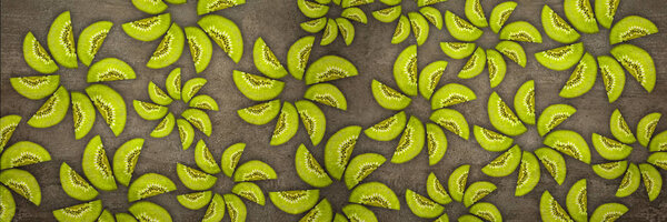 Creative flowers made of Kiwis cut from below lit on a stone background Food concept