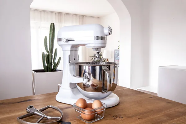 Máquina de cocina blanca y batidora de pie en una mesa de madera en un apartamento de diseño brillante —  Fotos de Stock