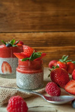 Düşük Carb çilek ve chia pudingler bir cam, ahşap arka plan