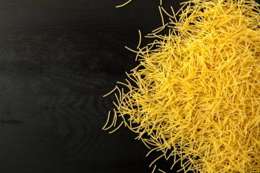 Erişte makarna çeşitleri ahşap bir siyah arka plan dokulu. Üstten Görünüm yakın çekim. Metin için boş alan.