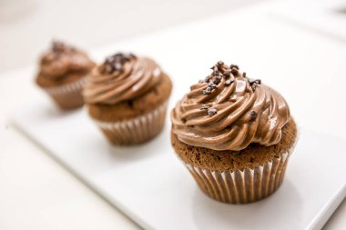 Beyaz plaka ve masa çikolata cupcakes