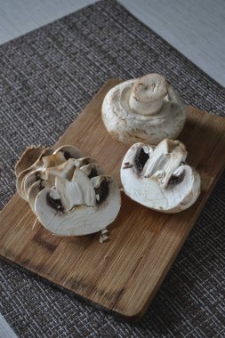 bir kesme tahtası üzerinde champignon mantar dilimlenmiş