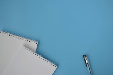 Yeşil çiçekli ahşap bir masa üzerinde siyah kalem ile beyaz spiral not etmek