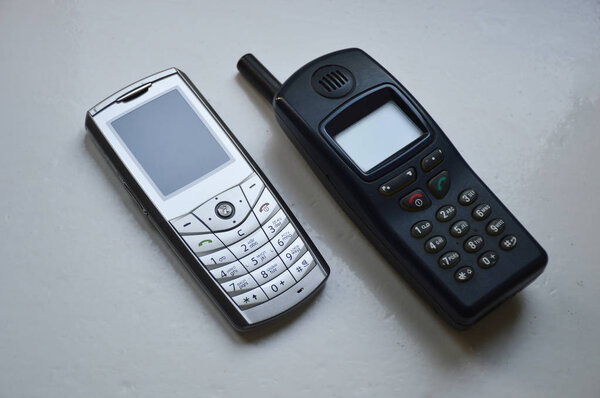 Два старых телефона на белом фоне
