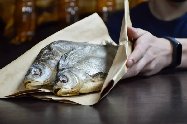 Venditore Tiene Pesce Essiccato Carta — Foto Stock