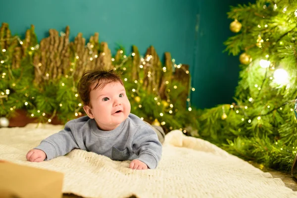 Koncepcja Baby i Christmas. Baby z tła Bożego Narodzenia w sezonie zimowym, Baby zdrowe i zimowe pojęcie. Święta nowego roku. prezent pod drzewem. — Zdjęcie stockowe