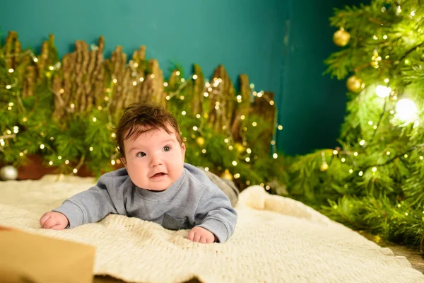Dziecko w pobliżu choinki. Mały chłopiec obchodzi Boże Narodzenie. Babys pierwszy Boże Narodzenie. — Zdjęcie stockowe