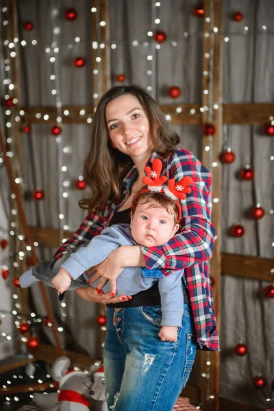 Christmas and mother concept. Christmas and people concept - mother and baby with gifts. On a Christmas background. warm christmas.