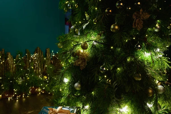 Weihnachtsbaum mit grüner Hintergrundbeleuchtung. Festliche Dekoration für Weihnachten und Neujahr hautnah auf Fichte. — Stockfoto