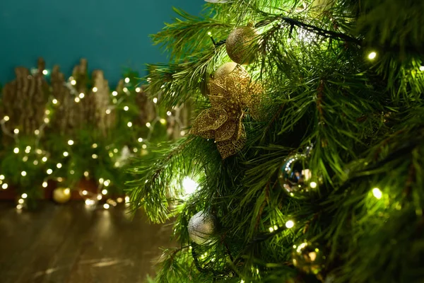 Karácsonyfa zöld háttérvilágítással. Ünnepi dekorációk karácsonyra és szilveszterre közelkép lucfenyőről. — Stock Fotó