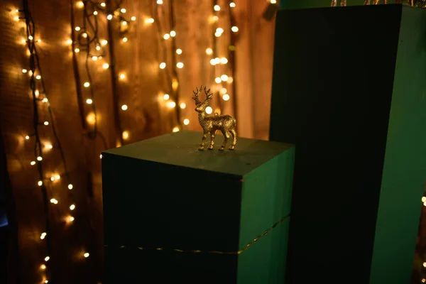 Χριστουγεννιάτικο ελάφι. Λευκό ελάφι παιχνίδι. Μικρό άγαλμα λευκού ελαφιού σε φωτογραφικό στούντιο και θολό σκούρο φόντο με κίτρινες λόγχες. Χριστουγεννιάτικο θέμα — Φωτογραφία Αρχείου
