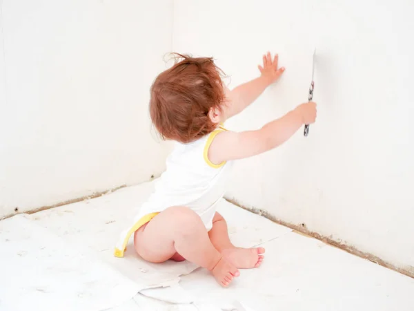 修理和婴儿。 男孩与仪器翻新公寓隔离在一个白色的背景。 墙纸，粘贴配件，油漆工具。 房屋维修。 父母童年的概念。 修理中 — 图库照片