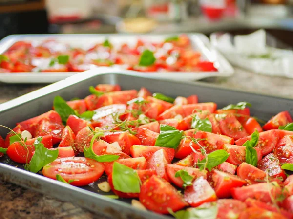 baking tomatoes. Dried tomatoes in a baking sheet and spatula. strewn with seasonings and herbs