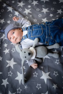 Yatakta pelüş oyuncağı olan bir bebek. Tavşan şeklinde bir oyuncak. Uyumak için favori bebek oyuncağı.