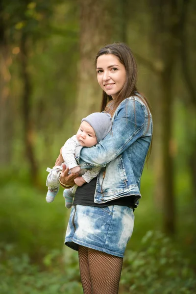 Sıcak anne elleri. Mutlu anne bebeğini kucağında gezdirir. Anne mutlu bir çocukla konuşur, çocuk annesinin kollarında oturur..
