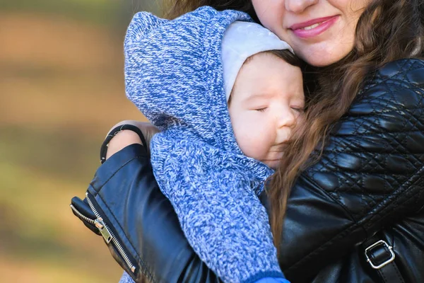 Bebek annesinin kollarında uykuya daldı. Annenin sıcak kucaklaması bebeği sakinleştirdi. Uyumak için sıcak hava. Annenin kollarında güvende. — Stok fotoğraf