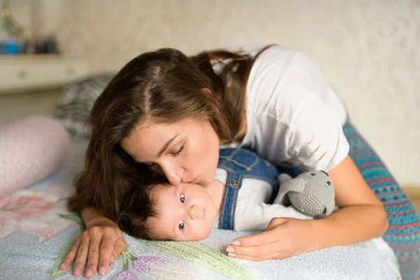 Mom with a child in bed. Happy loving family. Mother and her daughter child girl playing together. — Stock Photo, Image