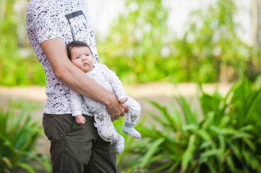 Babasının kollarında yeni doğmuş bir bebek. Bir baba yeni doğmuş bebeğini kollarında tutuyor. Mutlu baba.