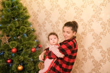 Çocuklu annem Noel ağacı hazırlıyor. Aile, Noel, kış tatili ve insanların konsepti. Mutlu anne ve küçük oğlu evde Noel ağacı süslüyorlar.