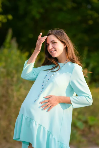 孕妇在大自然中行走。 一个怀孕的年轻女子在温暖的天气里站在室外的画像 — 图库照片