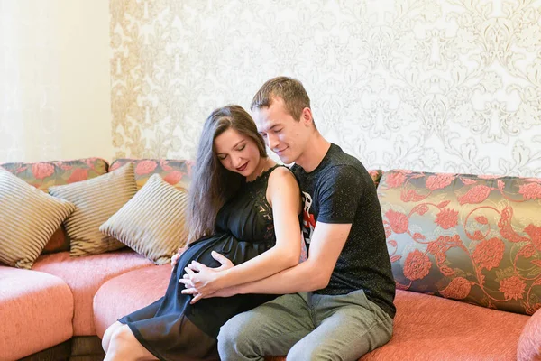 Das Paar erwartet ein Baby. Liebendes schwangeres Paar liegt im Bett, kuschelt, erwartet ein Baby — Stockfoto
