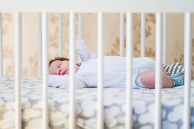 Bebek beşikte uyuyor. Sevimli kız uyumak için bir yatakta uyuyor, ebeveynlerinin yatağına bağlı. Beşikte şekerleme yapan küçük bir çocuk. Güneş kreşindeki bebek