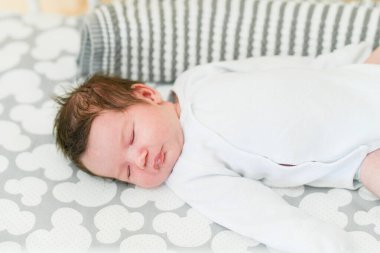 Çocuğunun evde ilk günü. Yeni doğmuş bebek hayatının ilk günlerinde uyur. Sevimli küçük bebek huzur içinde uyuyor.