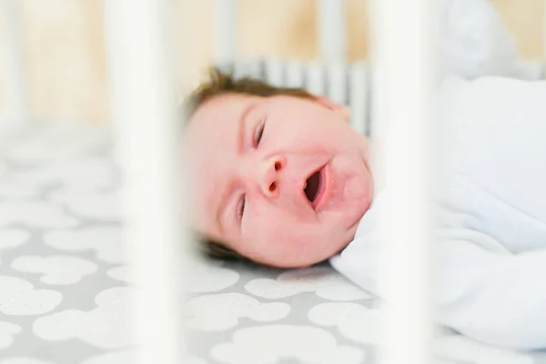 Ziewające dziecko. Senny ziewanie dziecko z rękami w górze w sypialni rodziców — Zdjęcie stockowe