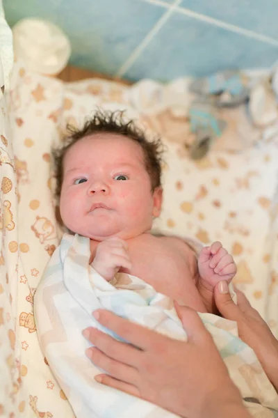 Mère frotte bébé après le bain. le garçon sourit et se sent heureux après avoir pris un bain. mère sèche et frotte les cheveux du nouveau-né et la tête avec une serviette après avoir pris une douche. concept de famille et — Photo