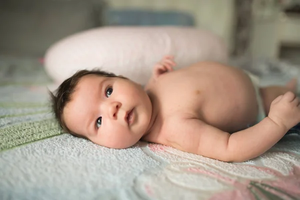 Baby van dichtbij. liggend op de bank in de ouderkamer. foto van een pasgeboren baby opgekruld slapen op een deken — Stockfoto