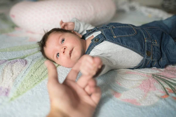 El niño sostiene el dedo. Mano de bebé sosteniendo suavemente el dedo de adulto . — Foto de Stock