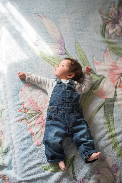 Dítě leží na posteli. Roztomilé děťátko ležící na posteli, výhled shora — Stock fotografie