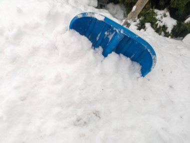Kar yığınında kürek. Şimdi kürek. Karda yakın çekim. Kar temizleme, kar yağışı, çok miktarda yağış kaybı konsepti.