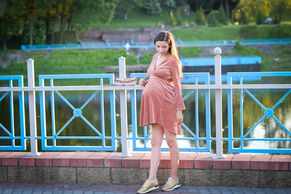 Ragazza incinta con un vestito beige. Ragazza bruna incinta in un abito beige. In previsione di un bambino. Futura mamma — Foto Stock