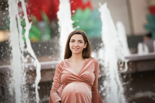 Ragazza incinta con un vestito beige. Ragazza bruna incinta in un abito beige. In previsione di un bambino. Futura mamma — Foto Stock