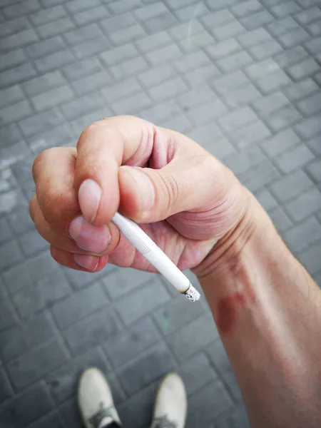 Brûler une cigarette. Cigarettes, toxicomanie et santé publique : comment les cigarettes affectent la peau — Photo