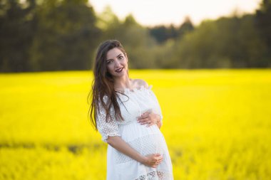 Yaz hamileliği, sıcak mevsimde. Sıcak bir yaz gününde hamile bir kadının güzel bir portresi. Hamilelik ve sezon konsepti